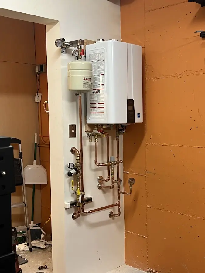 Plumbing technician inspecting water heater connections in Shorewood Forest